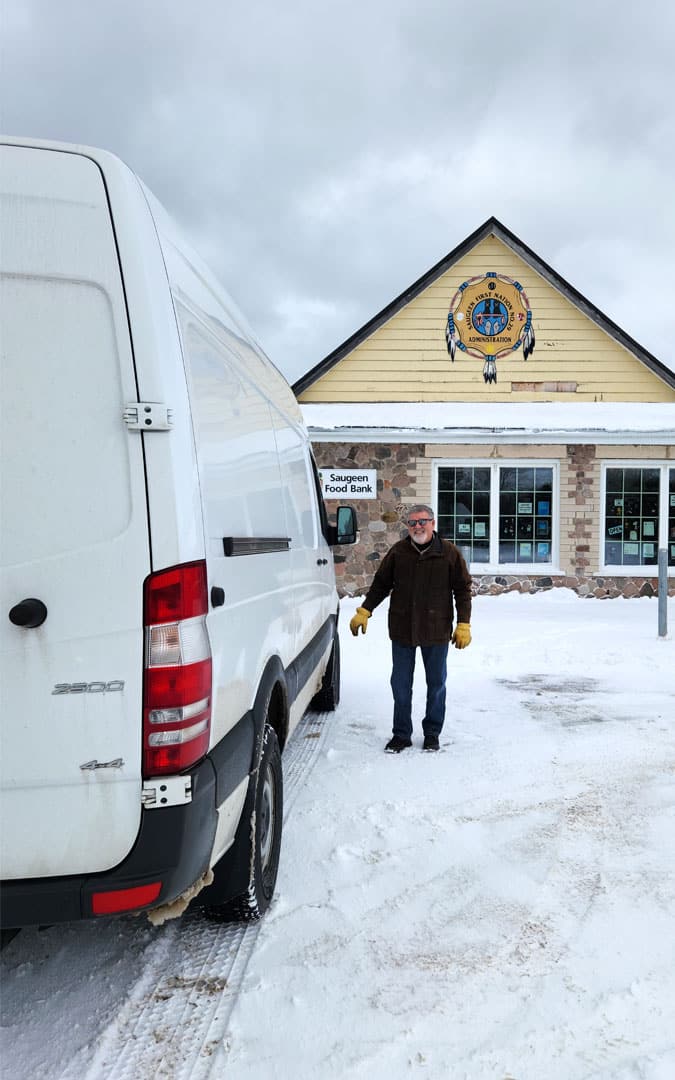 An image of a man standing outside the Saugeen First Nation Food Bank building.